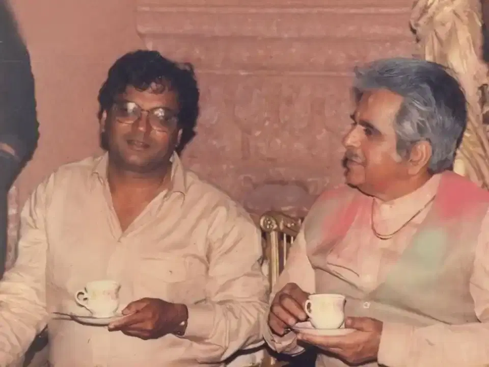 Two men sharing a cup of tea, from the Mukta Arts archive
