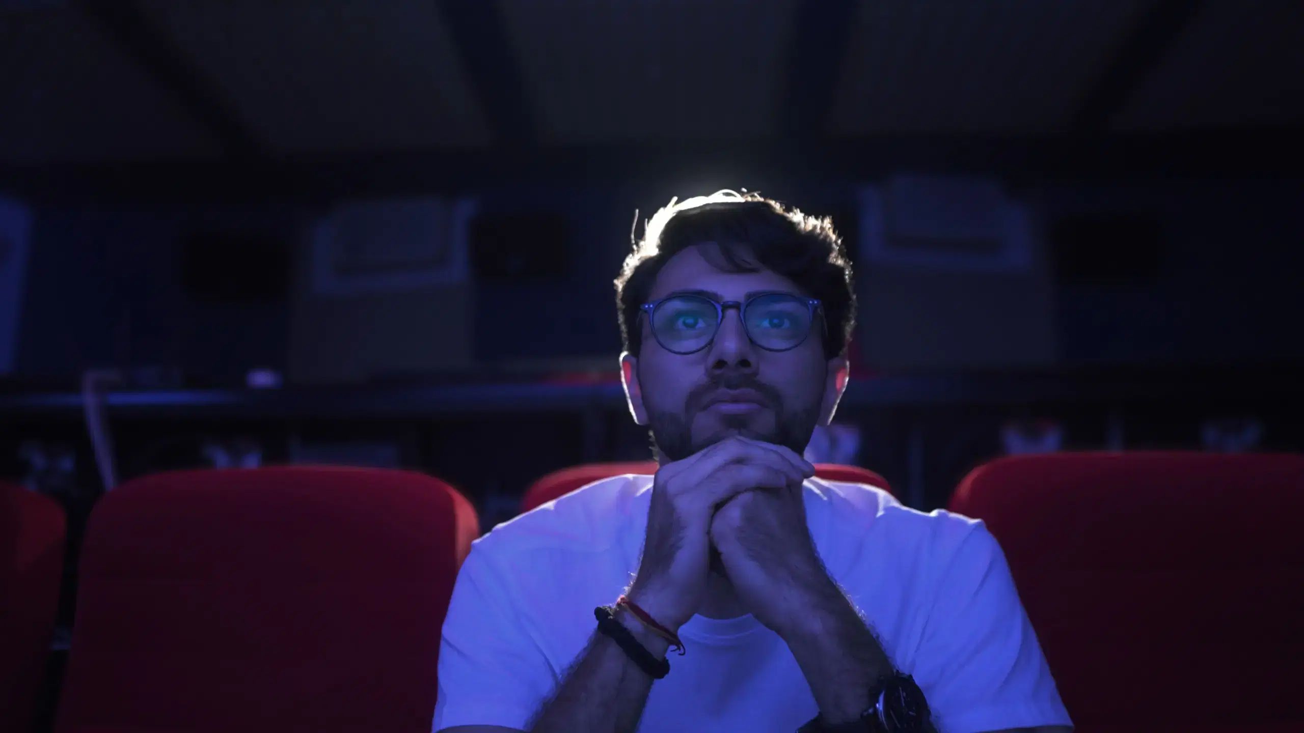 Student watching a film in a darkened cinema auditorium
