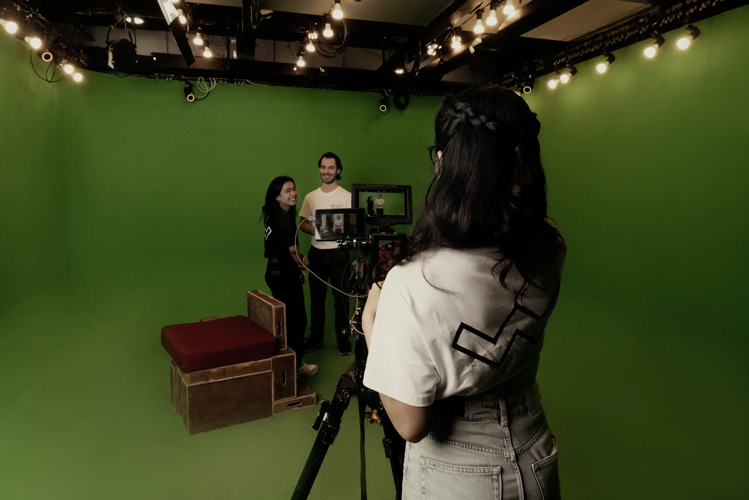 Students filming in a green screen studio
