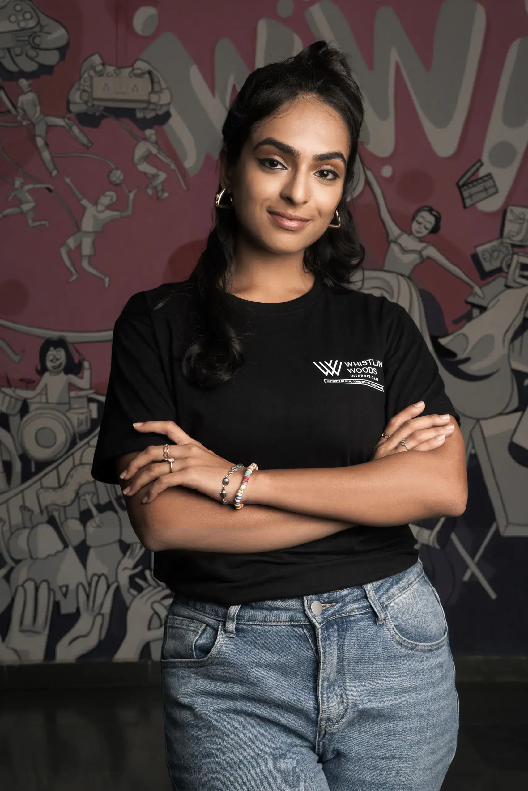 Whistling Woods student in front of a comic-style mural