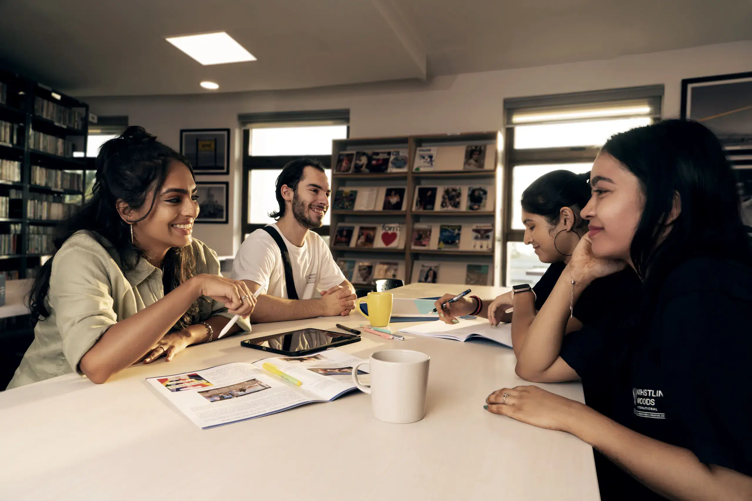 Students talking around a table in the Whistling Woods library