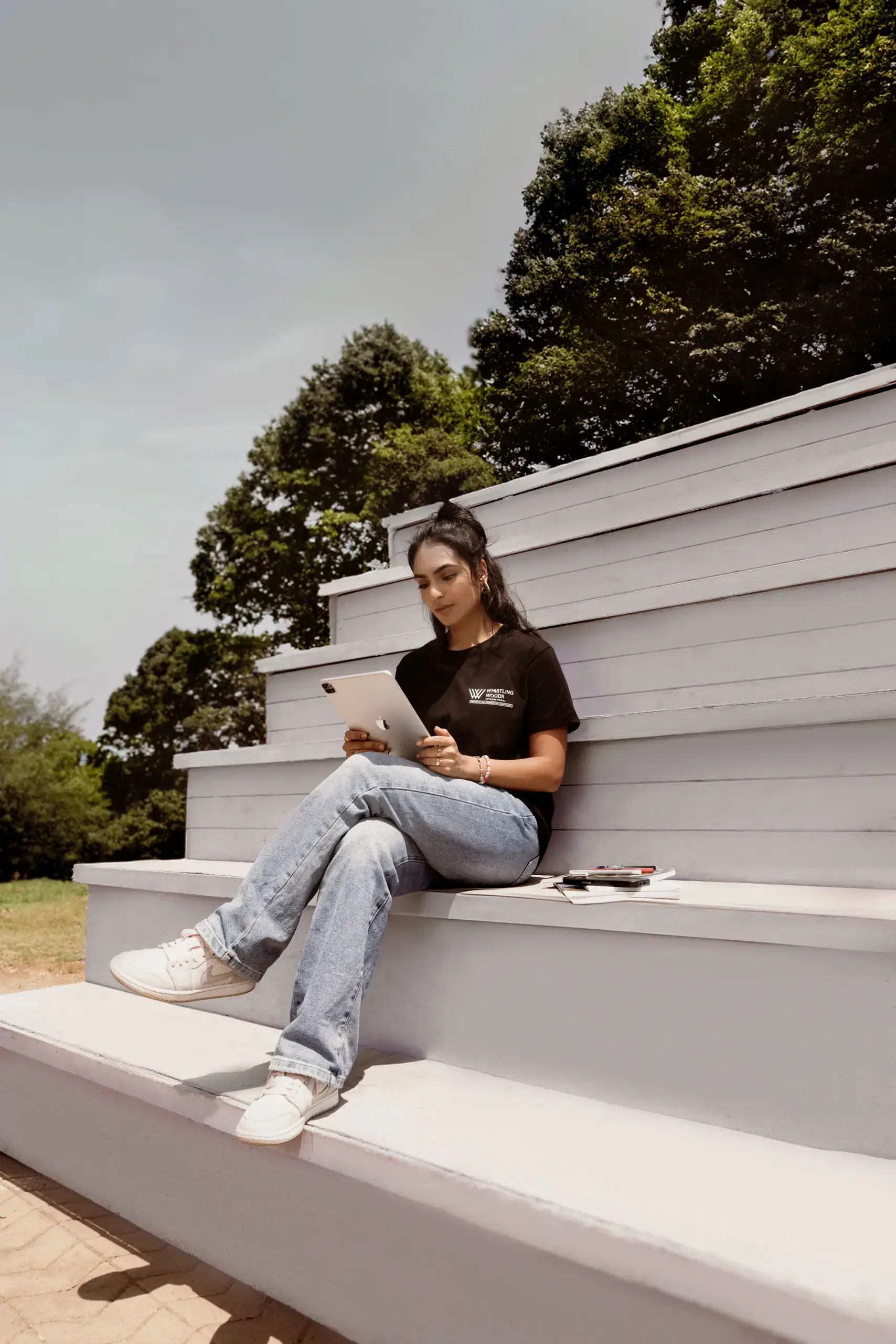 Student sitting on white amphitheatre steps on campus