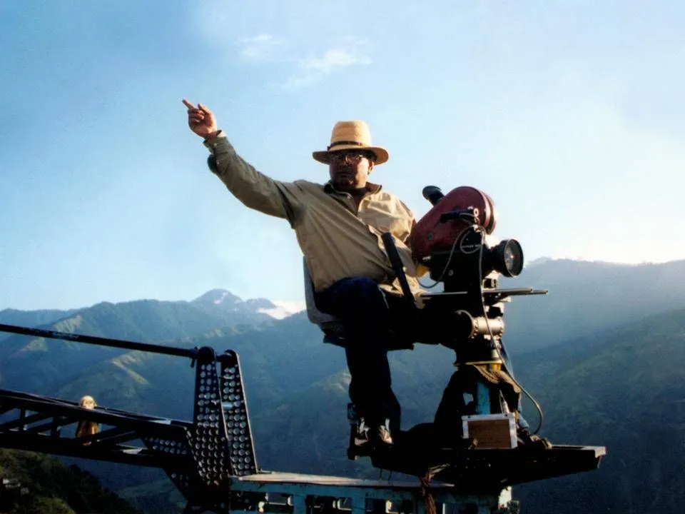 Filmmaker on a camera crane directing a shot in the mountains